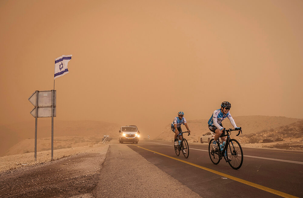 Israeli cycling team racing through dust storm